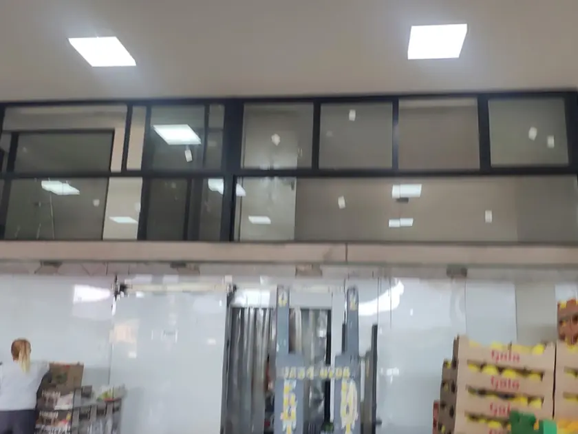 Mezanino administrativo com esquadrias de vidro sobre câmara fria