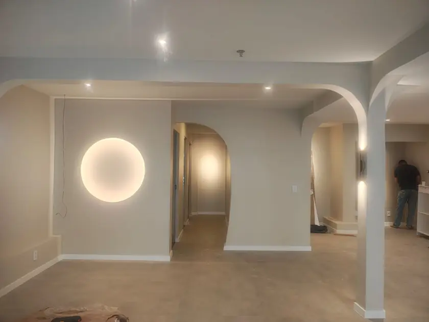 Parede com luminária circular embutida e passagem em arco