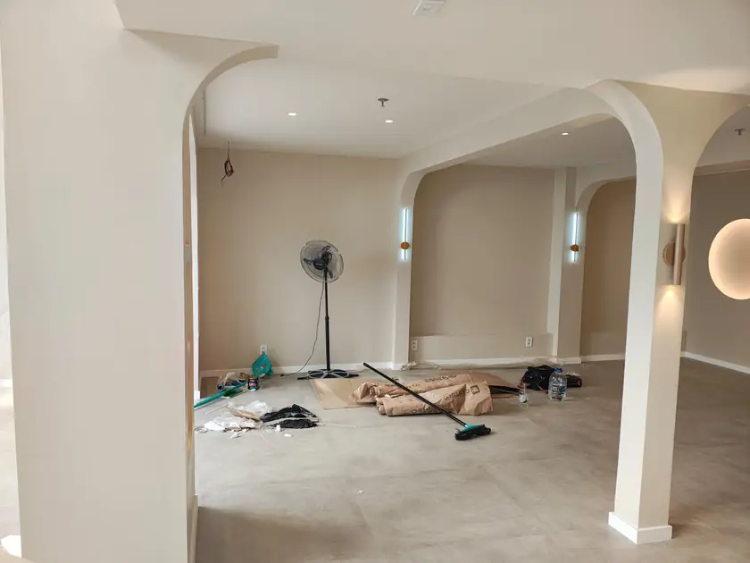 Ambiente com arcos em gesso e arandelas lineares
