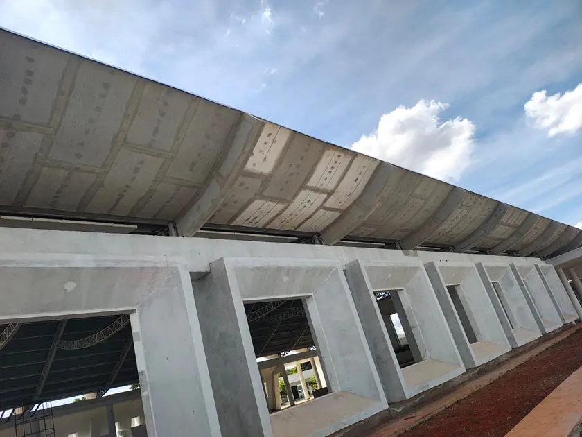 Fachada em concreto com janelas recuadas e cobertura curva
