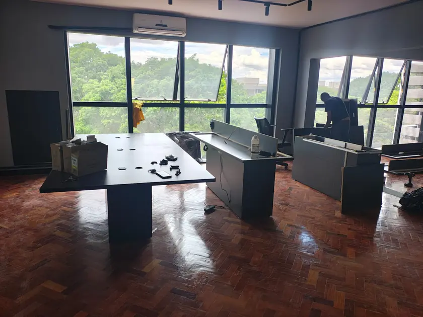 Escritório com esquadrias amplas e piso em taco